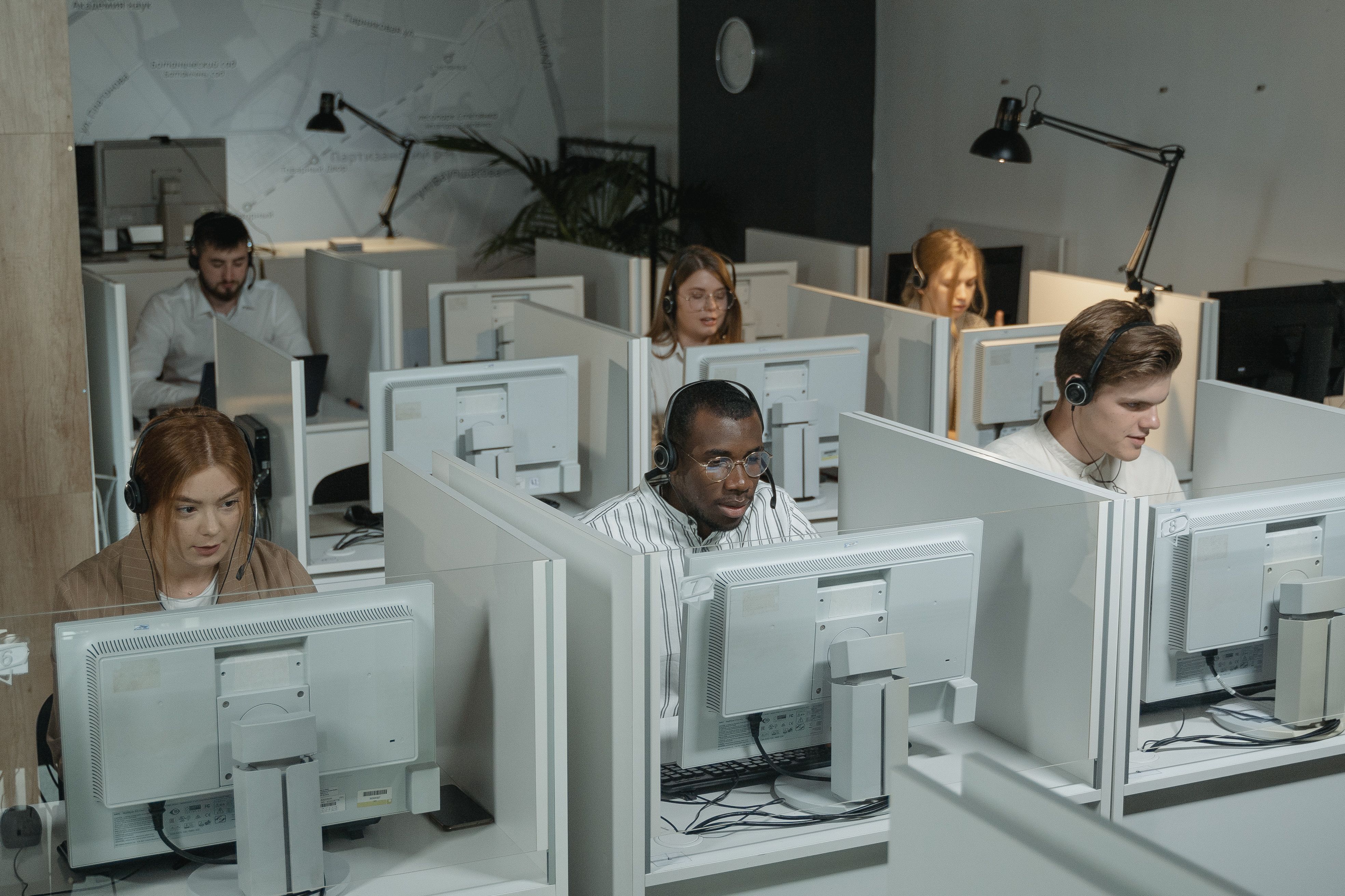 Call center agents wearing headsets working at their desks